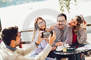 Group of friends having fun in cafe, make selfie photo