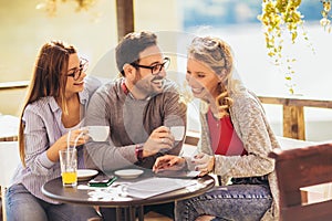 Group of friends having fun in cafe, using digital tablet
