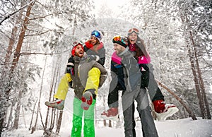 Group of friends having fun in forest on the snow