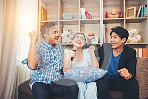 Group of friends having fun at living room singing a song