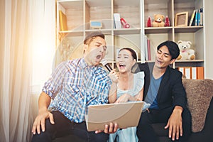 Group of friends having fun at living room singing a song