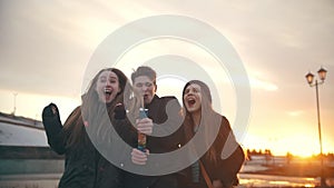 Group of friends having fun with party poppers confetti outdoors - slow-motion