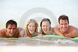 Group Of Friends Having Fun In Sea On Airbed