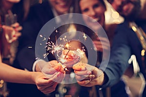 Group of friends having fun with sparklers photo