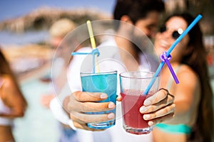 Group of friends having fun at summer party and drinking cocktail