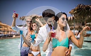 Group of friends having fun at summer party and drinking cocktail