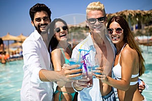 Group of friends having fun at summer party and drinking cocktail