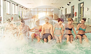 Group of friends having fun in the swimming pool