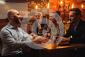 Group of friends having fun talk behind bar counter in a cafe