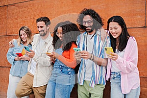 Group of friends having fun using a cellphone to browse on internet. Young adult people sharing photos with smartphone