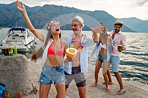 Group of friends having Hawaiian party on summer vacation. People fun travel concept.