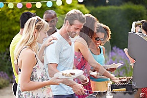 Group Of Friends Having Outdoor Barbeque At Home photo