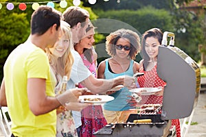 Group Of Friends Having Outdoor Barbeque At Home