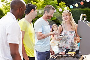 Group Of Friends Having Outdoor Barbeque At Home photo