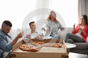 Group of friends having party, focus on pizza