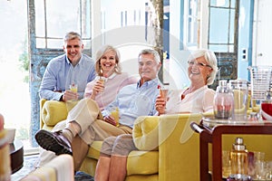 Group Of Friends At Home Relaxing In Lounge With Cold Drinks