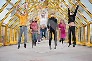 Group of friends jump on footbridge