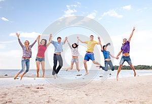 Group of friends jumping on the beach