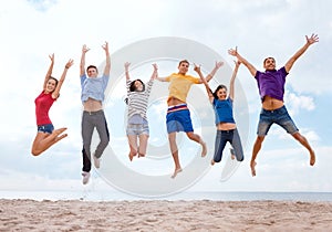 Group of friends jumping on the beach