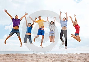 Group of friends jumping on the beach