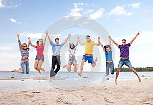 Group of friends jumping on the beach