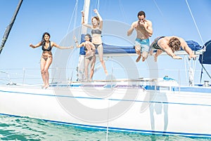 Group of friends jumping from the boat