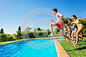 Group of friends kids jump and run into water pool