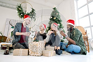 Group of friends laughing and drinkink champagne on Christmas Party