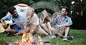 Group of friends listening to guy playing the guitar