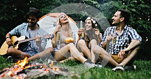 Group of friends listening to guy playing the guitar