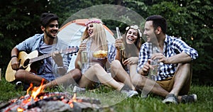 Group of friends listening to guy playing the guitar