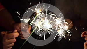 A group of friends lit sparklers together. People get ready for the holiday and light Bengal fires. The company of