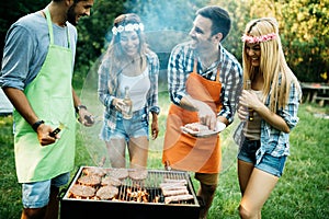 Group of friends making barbecue in the nature