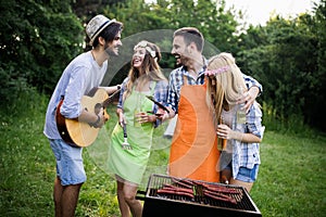 Group of friends making barbecue in the nature