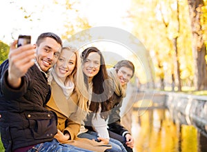 Group of friends with photo camera in autumn park