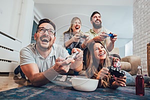 Group of friends play video games together at home