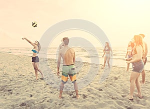 Group of friends playing with ball on the beach