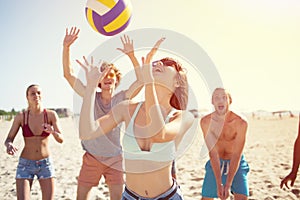 Group of friends playing at beach volley at the beach