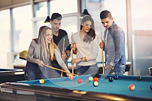 Group of friends playing billiard