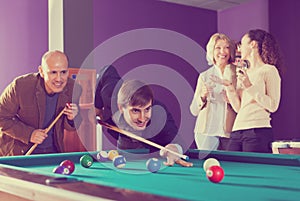 Group of friends playing billiards