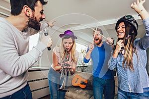 Group of friends playing karaoke at home.