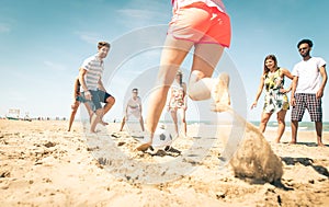 Group of friends playing soccer on the beach