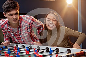 Group of friends playing table soccer at beer pub