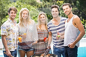 Group of friends preparing barbecue near pool