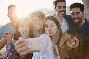 Group of friends pulling faces to selfie together