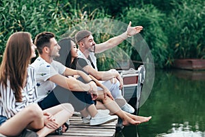 Group of friends relaxing on lake.