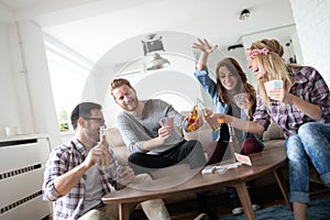 Group of friends relaxing and playing cards together. Young people hanging out together