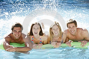 Group Of Friends Relaxing In Swimming Pool Together