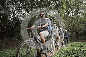 Group of friends ride mountain bike in the forest together