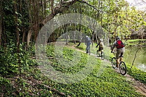 Group of friends ride mountain bike in the forest together photo